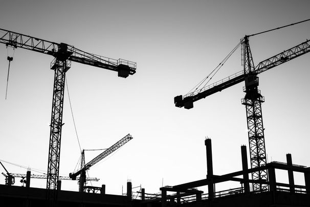 Image of construction cranes against the sky
