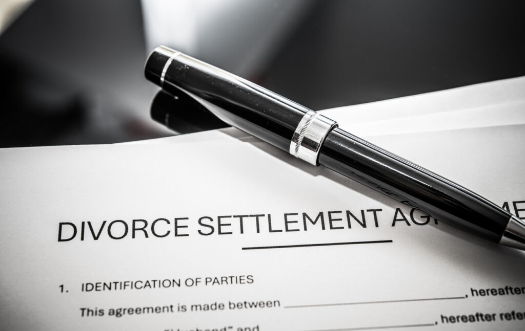 Close-up of divorce settlement agreement with pen.